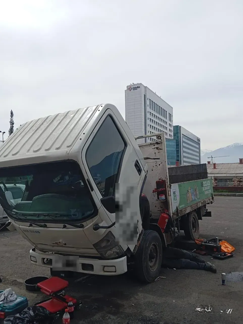 Mecánico trabajando bajo Chevrolet NKR 512 en cambio de embrague - DRAUTOMOTRIZ Peñalolén