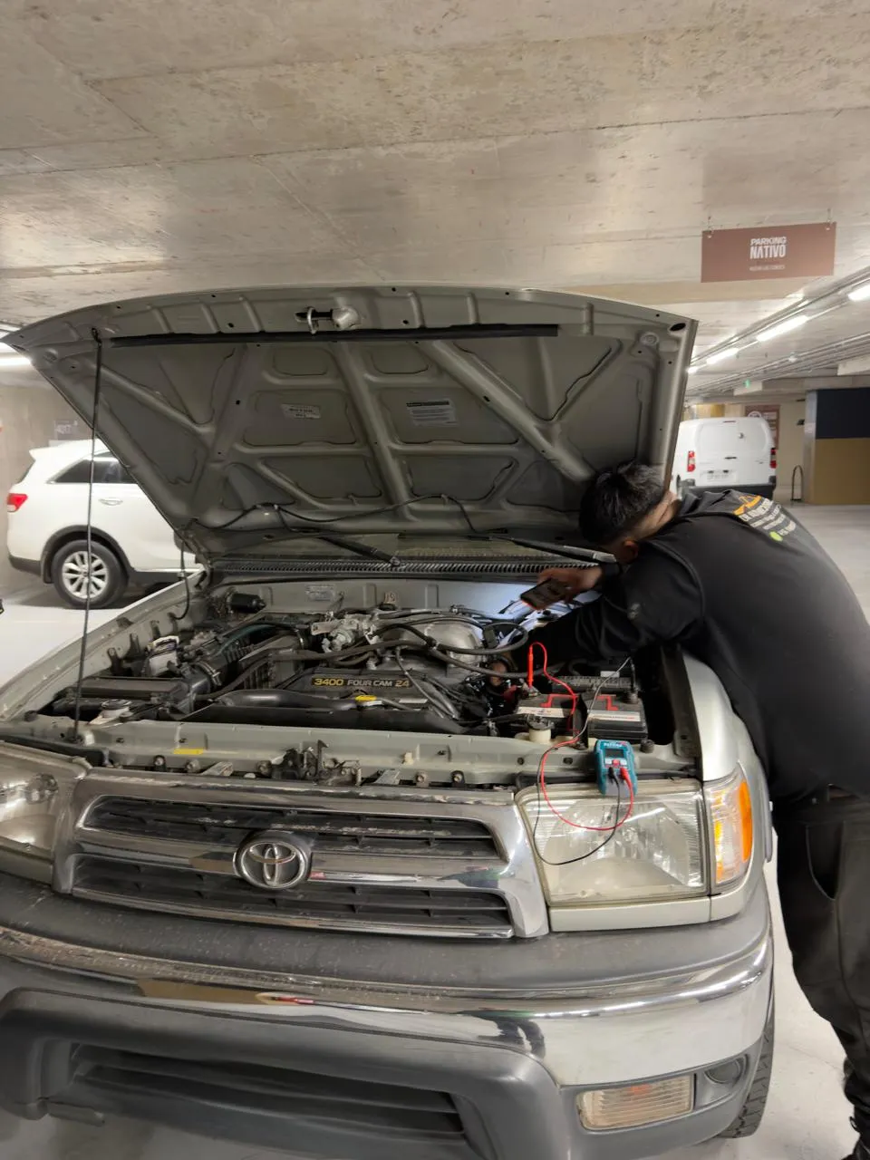 Mecánico revisando sistema eléctrico con multímetro en Toyota 4Runner - inspección pre compra a domicilio en Peñalolén